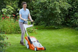 Tondeuse à gazon thermique STIHL en action sur une pelouse verdoyante