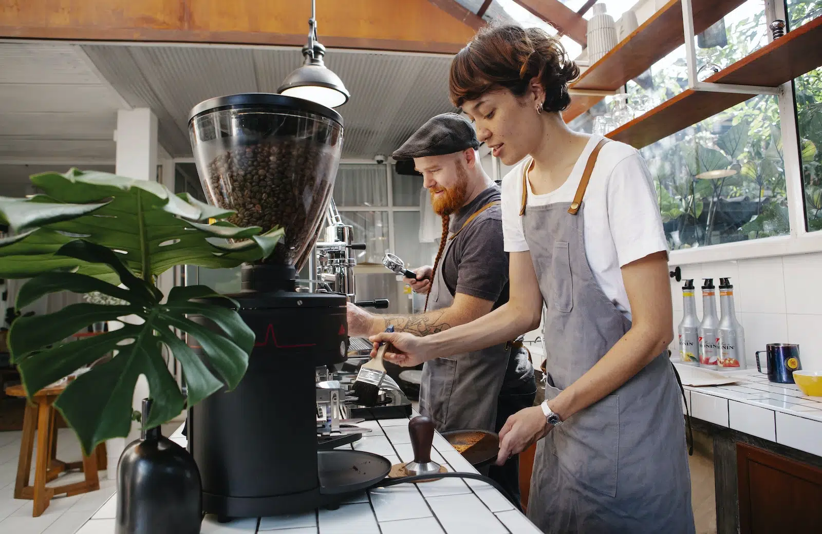 Baristas preparing coffee in machines in cafe kitchen