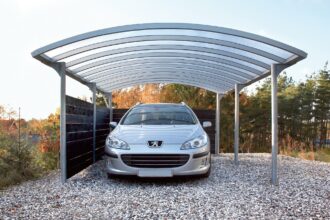 Carport en aluminium protégeant une voiture sous un ciel dégagé