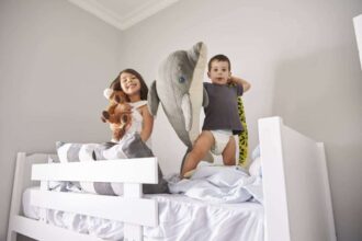 Lit superposé en bois dans une chambre d'enfant avec jouets et décor coloré