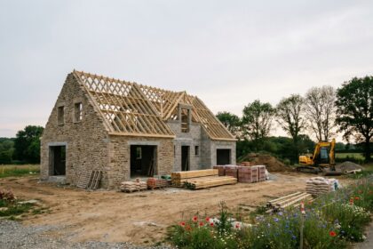 Chantier de construction d'une maison individuelle en périphérie de Vannes avec charpente en bois et murs en cours d'élévation