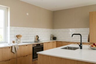 Vue d'ensemble d'une cuisine moderne rénovée avec plan de travail, évier, robinetterie et plaques de cuisson coordonnés