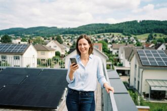 Femme souriante sur un toit avec panneaux solaires modernes