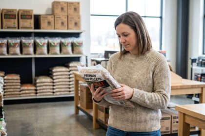 Femme examinant un sac de pellets de bois en magasin