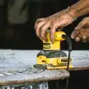 person holding yellow and black cordless power tool