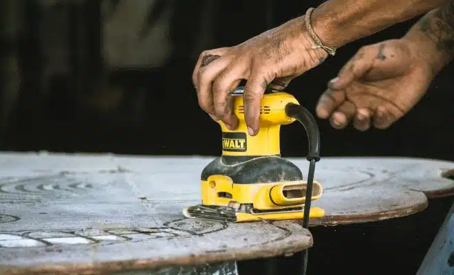 person holding yellow and black cordless power tool