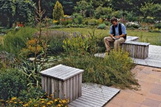 Paysagiste travaillant sur l'aménagement d'un jardin avec des plantes variées