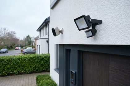 Caméra de surveillance et sonnette vidéo installées sur la façade d'une maison individuelle moderne