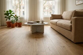 Salon moderne avec sol effet bois chêne clair, canapé beige et plantes vertes, ambiance cosy et naturelle