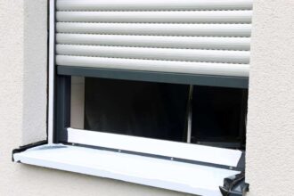 Volets roulants endommagés avec des lames déformées et des mécanismes visibles