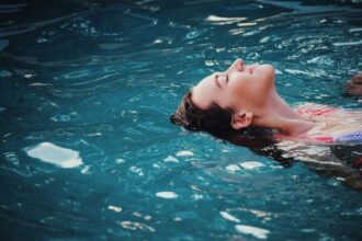 Femme profitant de sa piscine et des équipements extérieurs en été